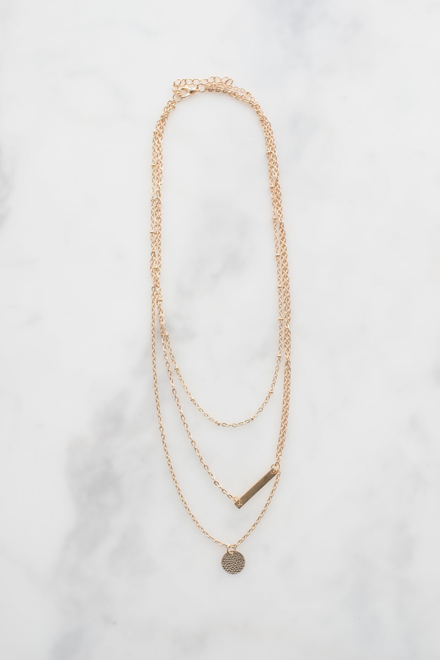 Small locket on a fine chain, on marble